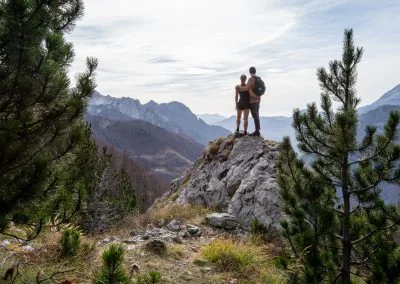 Selfie in the mountains of Teth, Valbona peak, Albania. Two people standing on a rock with mountains on the background.