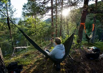 In a hammock with a sunset in the mountains of Norway.