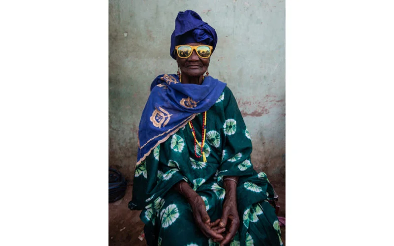 Old African woman wearing yellow sunglasses
